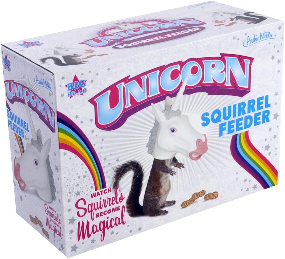 A novelty Unicorn Squirrel Feeder product box featuring a white unicorn head with a pink horn and gray mane dispensing peanuts to a real squirrel below. The packaging displays rainbow graphics and text reading "Watch Squirrels Become Magical" against a white background with stars.