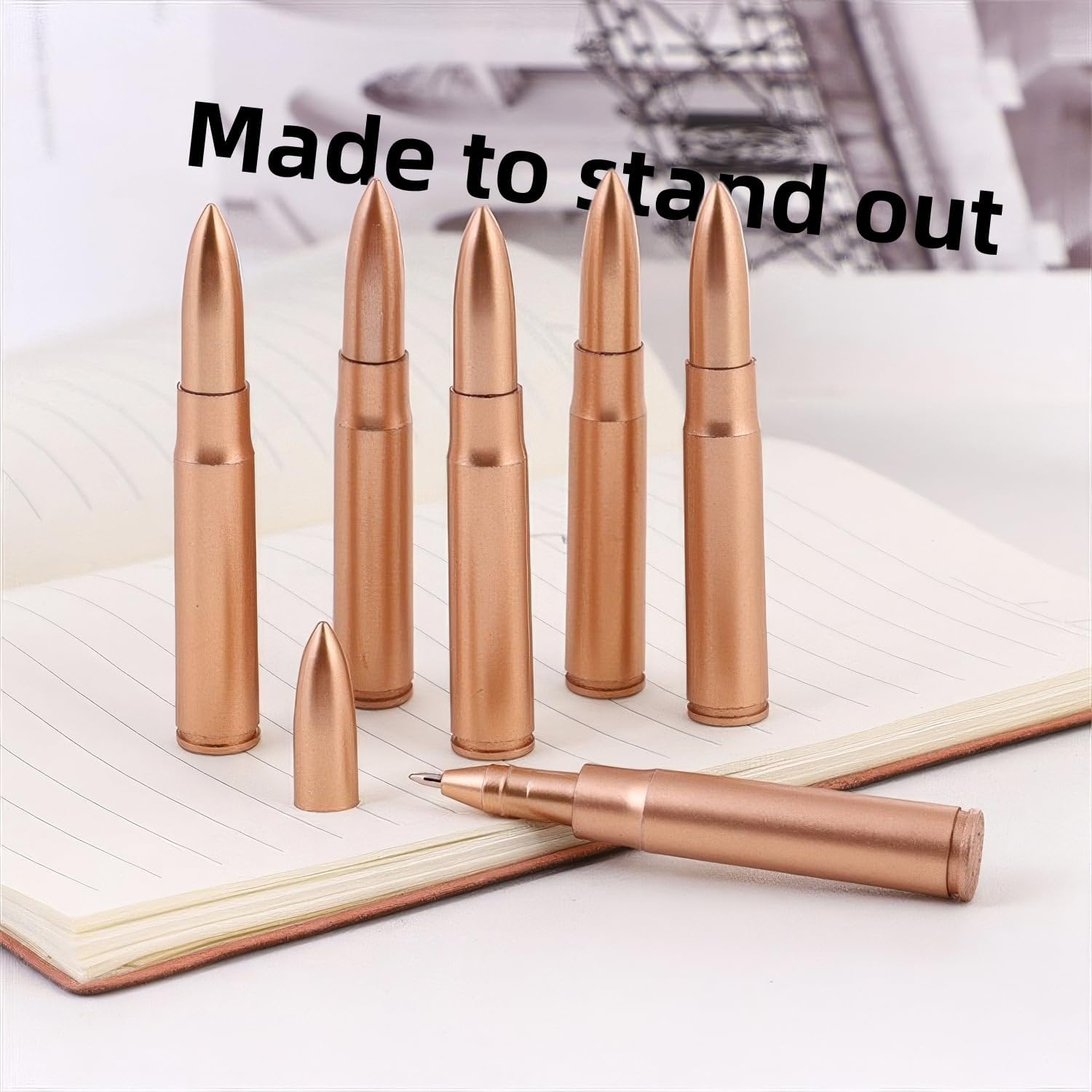 for Bullet Shaped PensCopper-colored bullet-shaped pens displayed on an open notebook, featuring realistic ammunition casing designs with pointed tips and functional ballpoint pen mechanisms.
