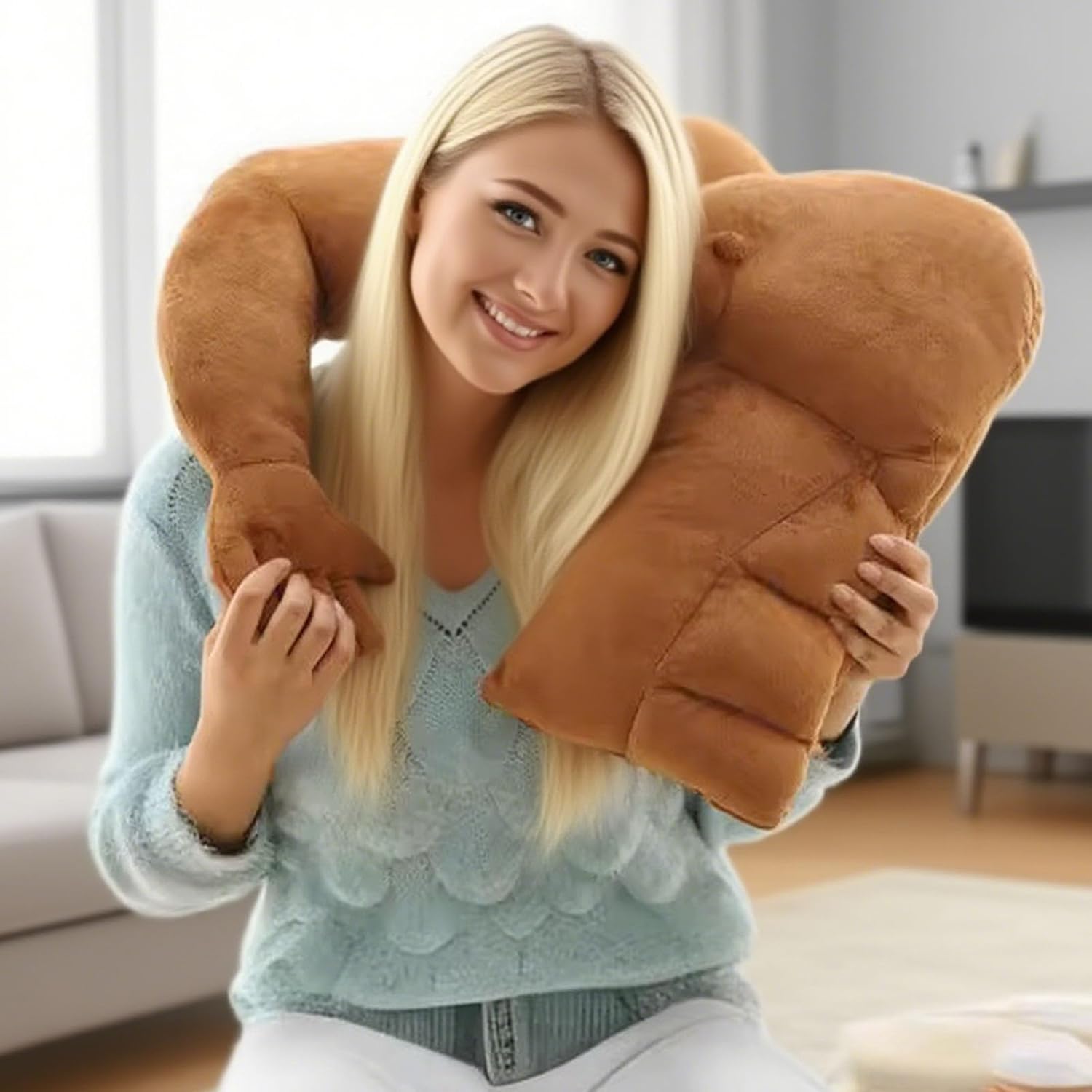 A novelty plush pillow shaped like oversized muscular arms in tan/caramel color, designed to simulate a comforting embrace when hugged while sitting or relaxing.